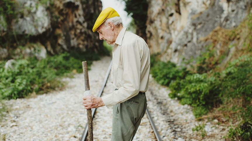 An elderly man looking pensive on the Burma railway line