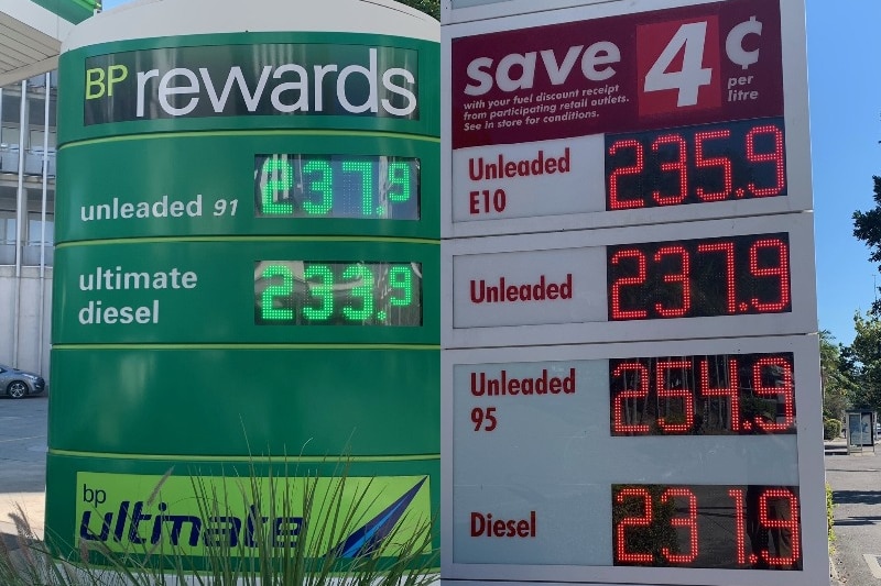 Signs outside two service stations indicate record-breaking hikes in fuel prices