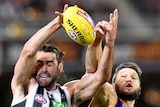 Brodie Grundy (left) and Stefan Martin make contact as they try to catch the ball in the air.