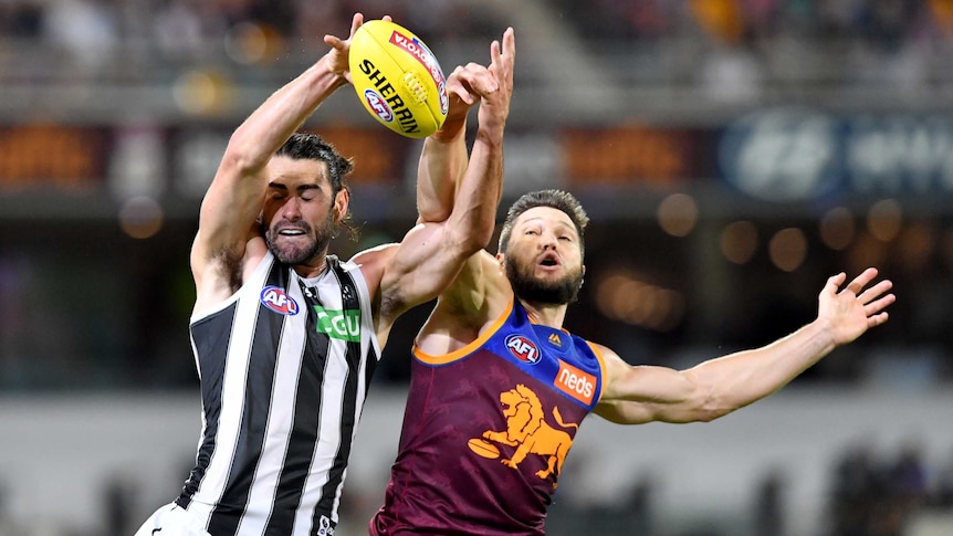 Brodie Grundy (left) and Stefan Martin make contact as they try to catch the ball in the air.