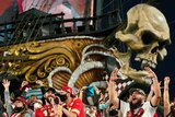 Super Bowl fans cheer in front of a pirate ship adorned with a skull at a stadium in Tampa.