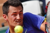 Bernard Tomic backhands at the French Open.