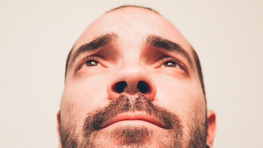 Close up of man's face looking up his nostrils