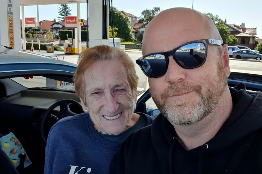 Selfie showing a smiling Merle and Dave (wearing sunglasses) at the petrol station.