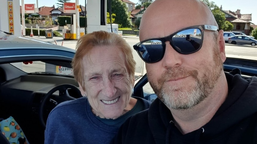 Selfie showing a smiling Merle and Dave (wearing sunglasses) at the petrol station.