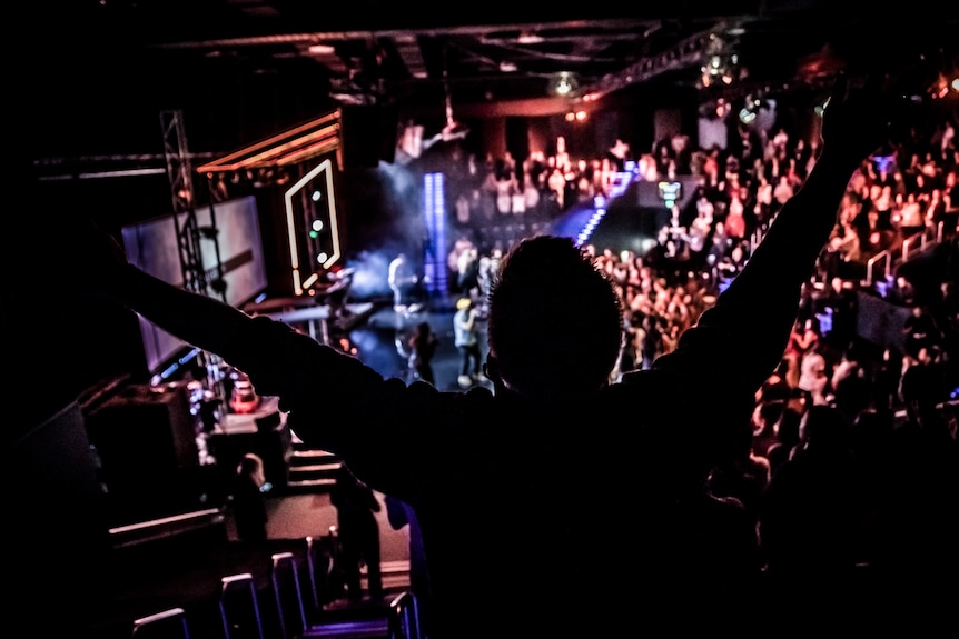 The silhouette of a man inside a packed church.