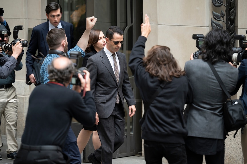 Jeremy Strong, in character as Kendall Roy in season 3 of Succession, is surrounded by photographers while walking down stairs