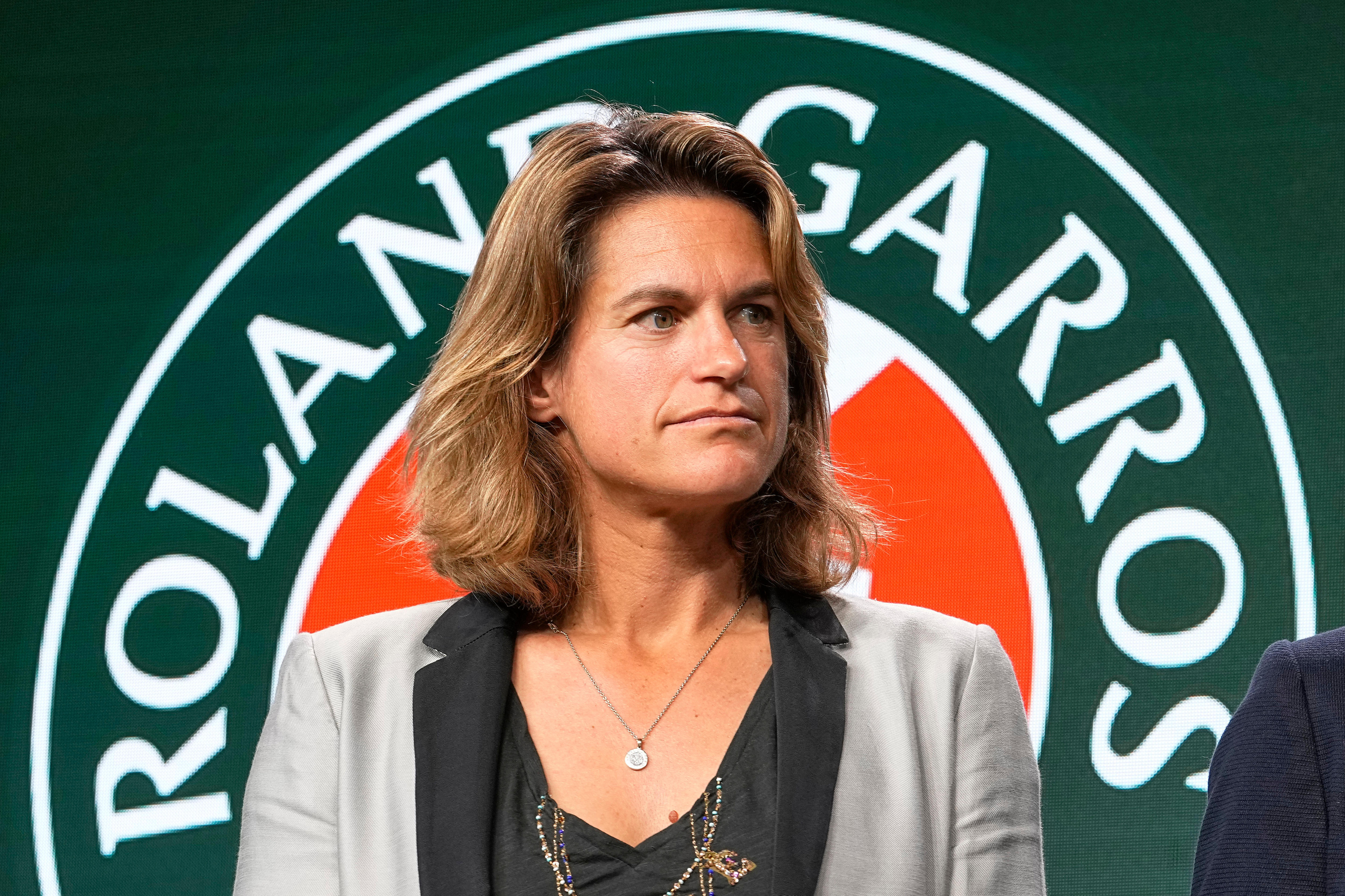 French Open director Amelie Mauresmo stands in front of a Roland Garros sign.