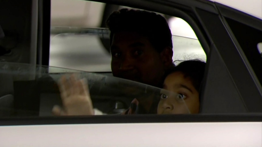 A man and child in the back of a car.