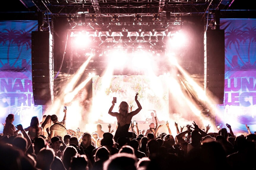 Young people at an exciting festival with bright lights.