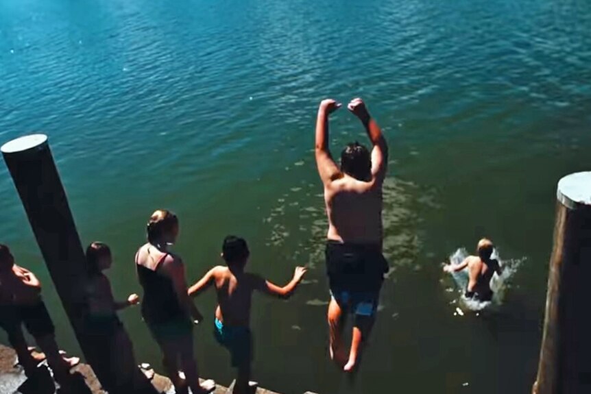 Coraki Public School students jumping into the river