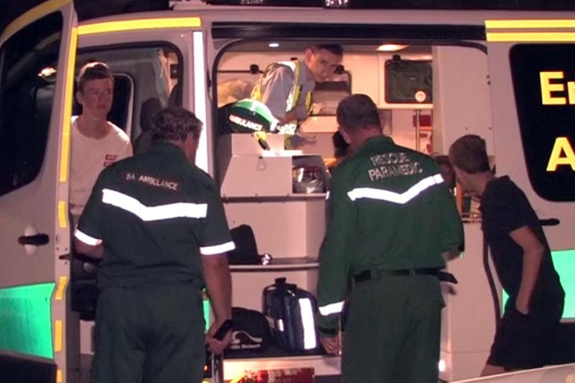 Ambulance staff treat teens after cliff rescue.
