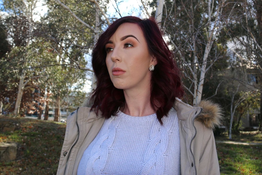 A close up of Teyarna Matheson standing outside with some trees behind her.