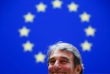 European Parliament President David Sassoli smiles in front of an EU flag