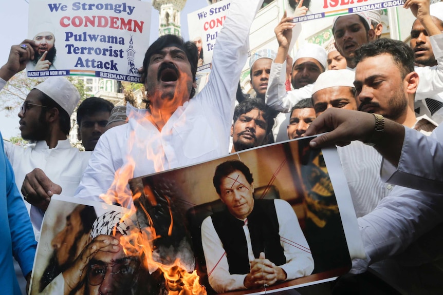 Indian Muslims burn posters of Pakistani prime minister Imran Khan.