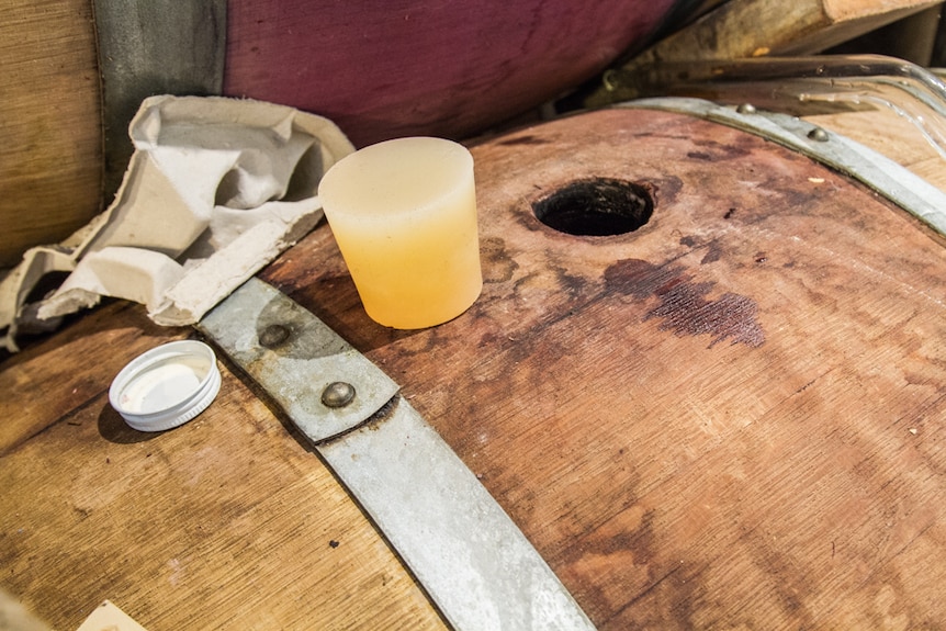 A wooden barrel with a plastic bung on top.