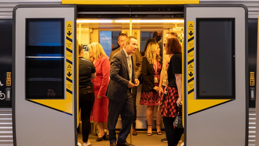 McGowan on a train surrounded by passengers 