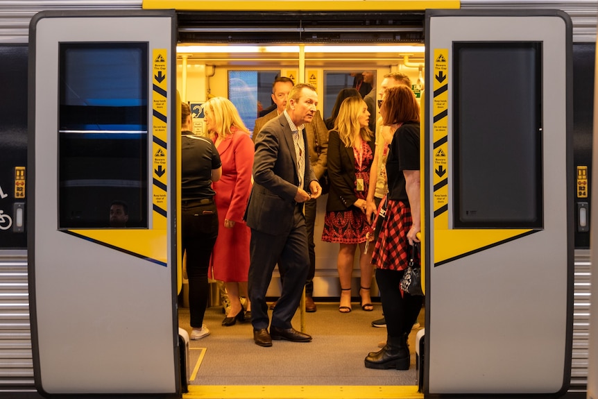 McGowan on a train surrounded by passengers 