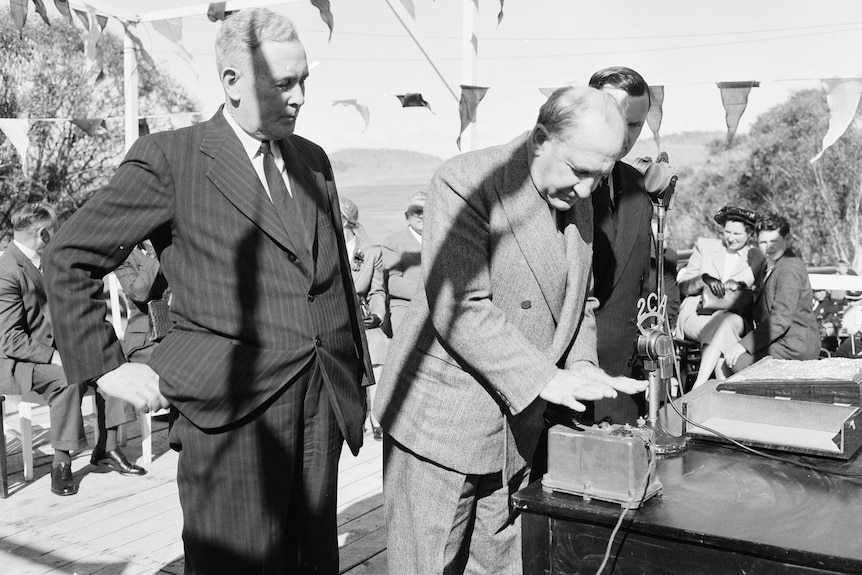 A 1949 photograph showing the Governor-General, Sir William McKell officially starting the construction of the Snowy Mountains Scheme by pressing a plunger to set off a charge of dynamite.