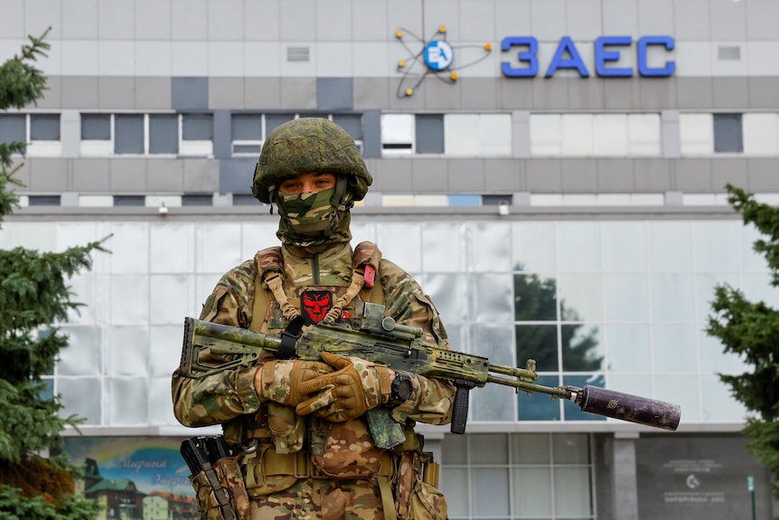 Soldier with rifle stands guard outside the Zaporizhzhia Nuclear Power Plant.