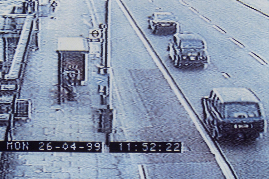 CCTV of a bus stop on a street as cars drive past