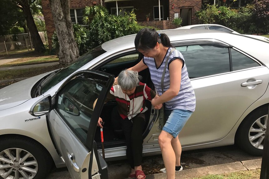 华裔老人被扶下车