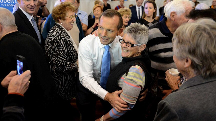 Tony Abbott poses for photos during a visit to a seniors forum on the Gold Coast