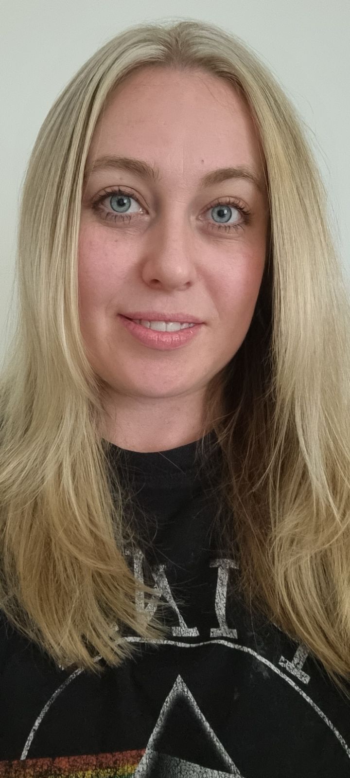 Blonde haired woman with blue eyes smiling