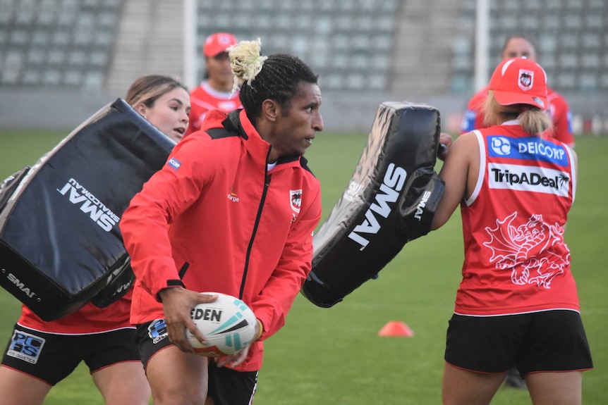 Elsie Albert is holding a rugby ball and looks like she's about to pass it during a training session.