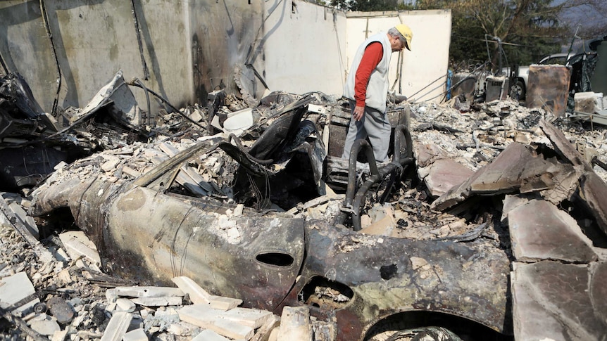 Personnel look for residents in a caravan park who did not make it out alive. (Image: Reuters)