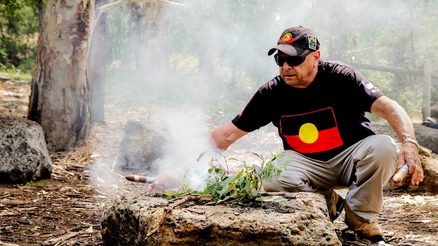 Aboriginal Indigenous elder Uncle Trevor Gallagher before a smoking fire in Darebin Parklands in inner city Melbourne.