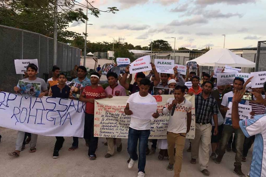Rohingya Muslims hold protest signs on Nauru.