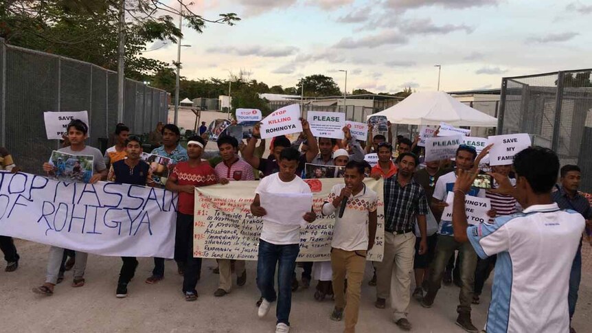 Rohingya Muslims hold protest signs on Nauru.