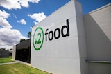 A sign reads v2food out front of a factory building.
