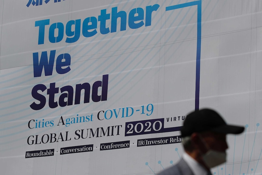 A man walks by a banner about an international online conference in Seoul.