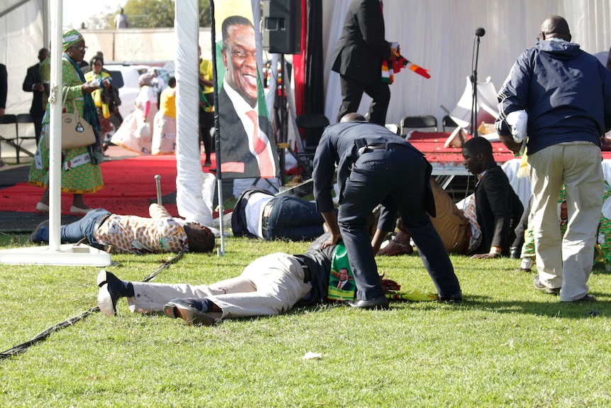 Injured people lay on the ground following an explosion