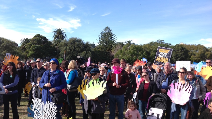 People gather in a park under blue skies.