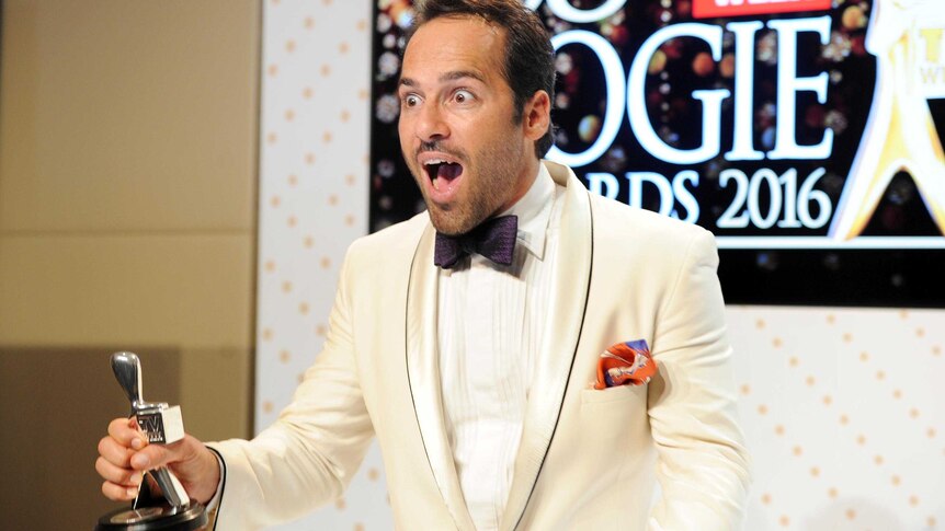 Alex Dimitriades looks startled as he holds his Logie in the press room after receiving his award.