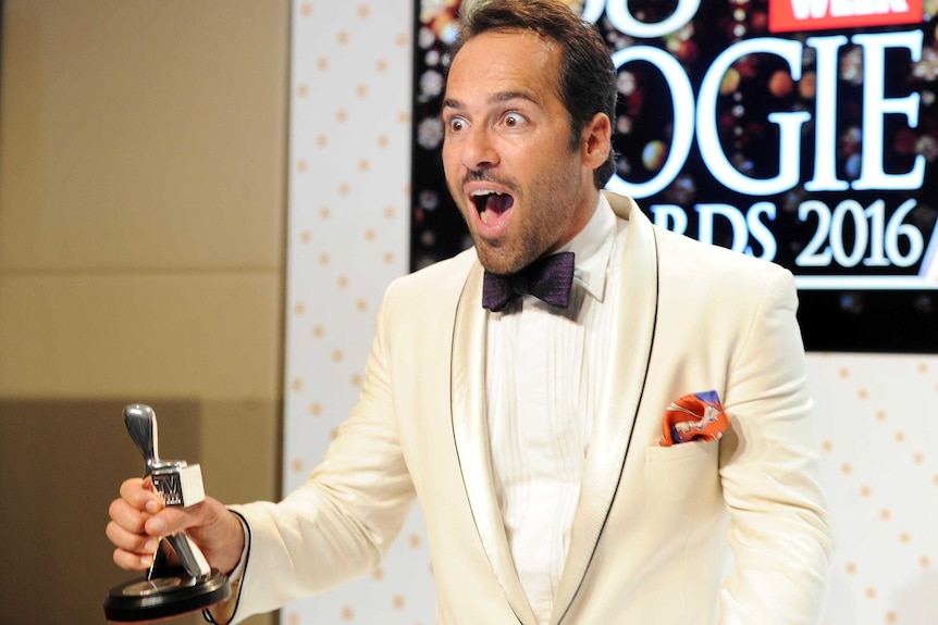 Alex Dimitriades looks startled as he holds his Logie in the press room after receiving his award.