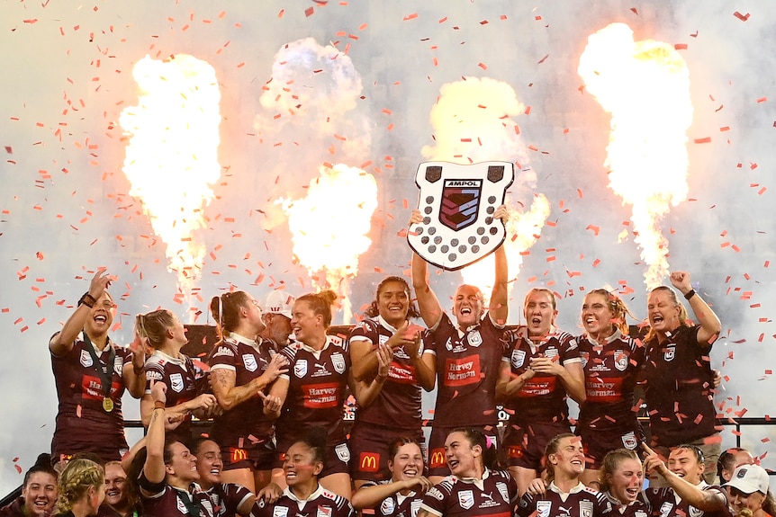 Queensland Maroons players lift the Women's State of Origin shield.