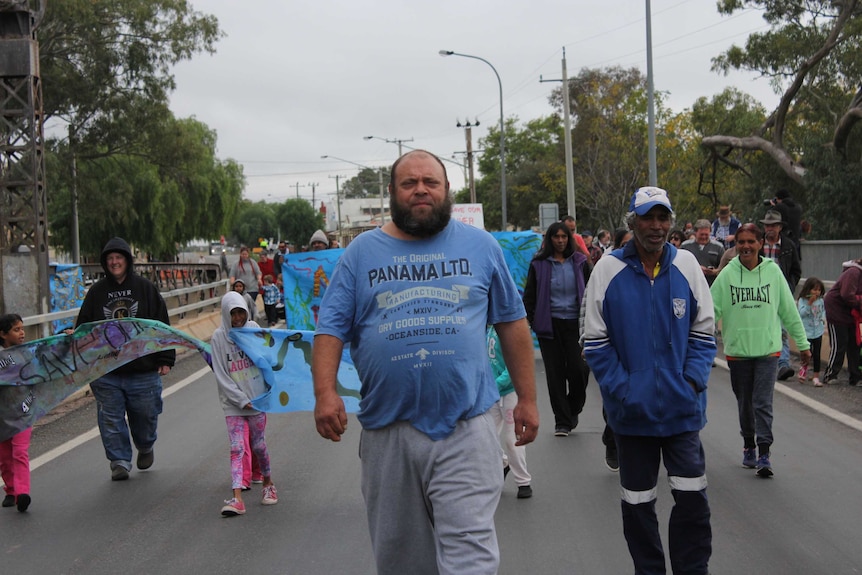 Murray Butcher leads protesters across the Wilcannia bridge.