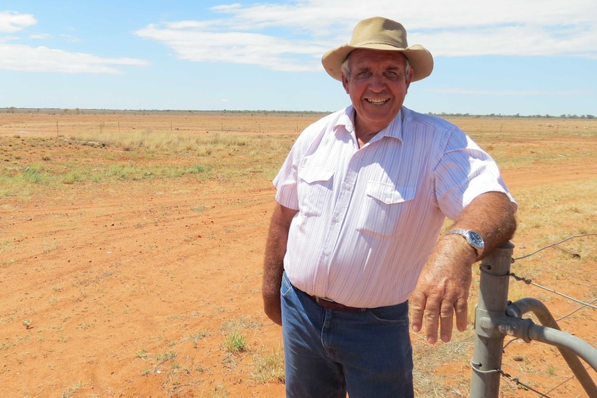 Geoff Morton leans on fence in paddock in outback Queensland in 2014.