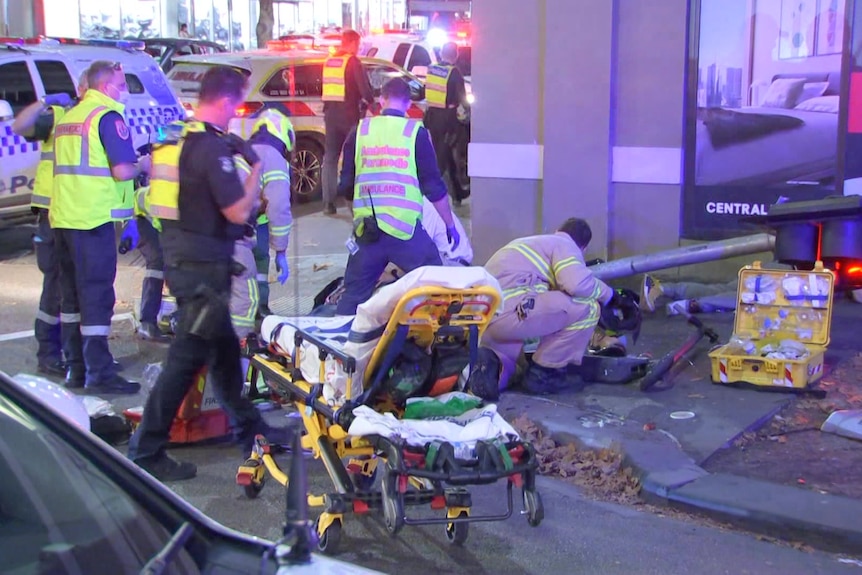 A group of emergency workers and an ambulance stretcher at a crash scene.