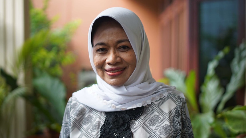 A head and shoulders shot of Siti Musdah Mulia. She is smiling against a balcony background.