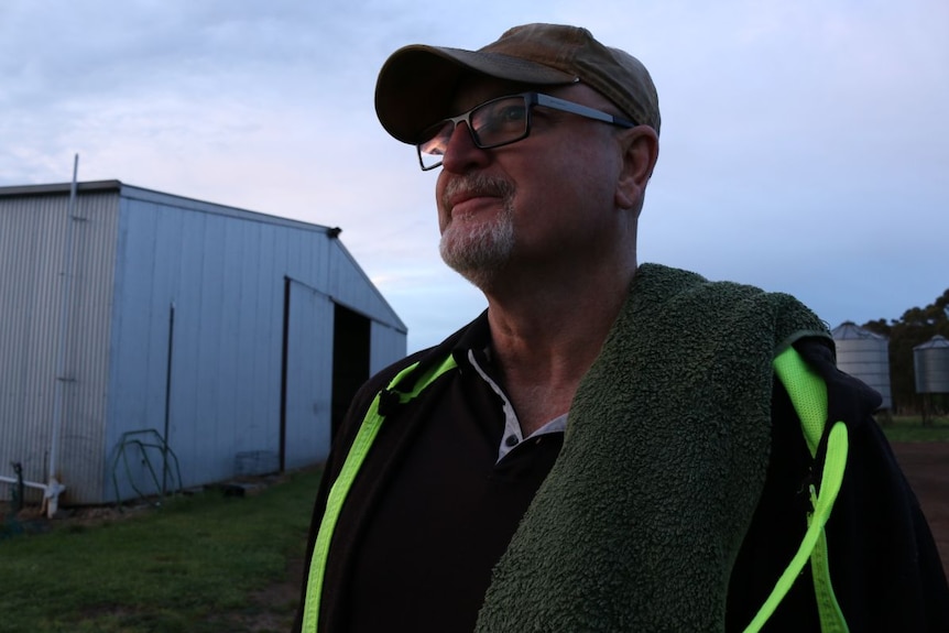 Rob Harrowfield looks into the distance in front of a shearing shed.