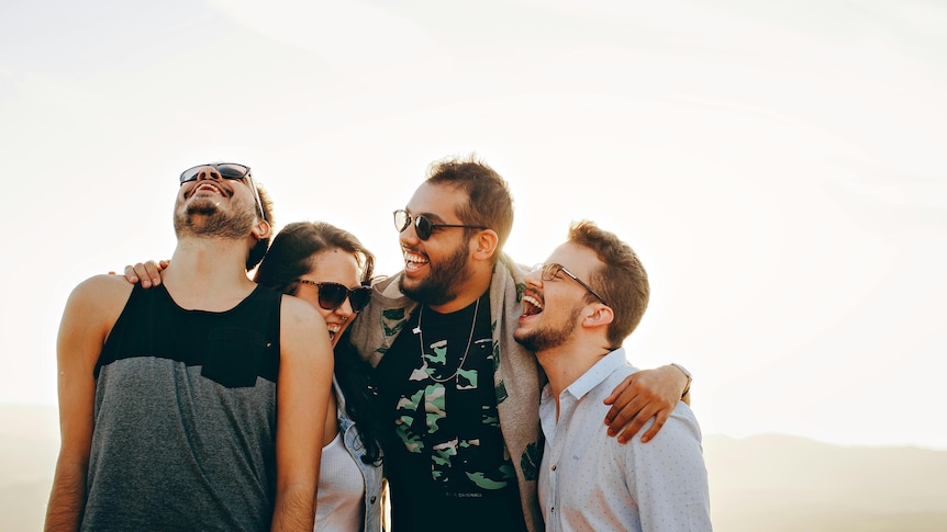 a group of young people smile together, generic image outdoors 