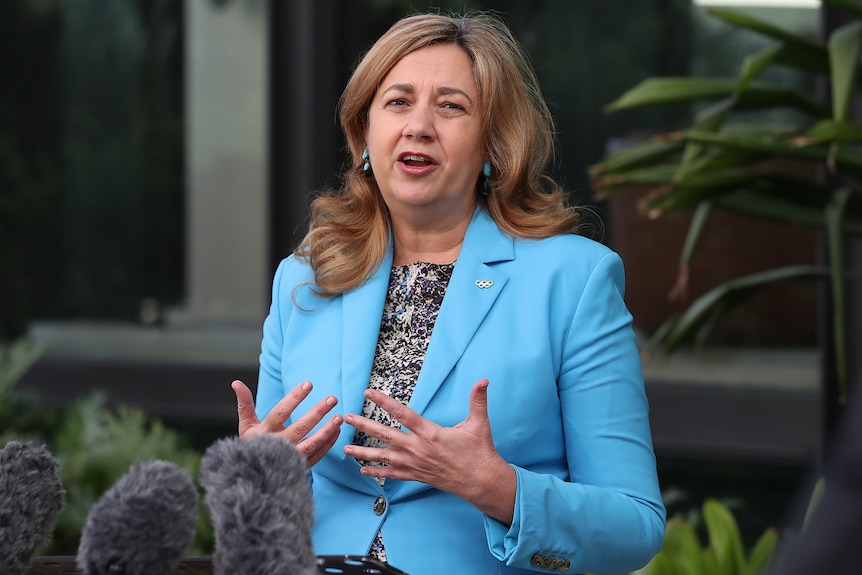 Annastacia Palaszczuk in a blue jacket outdoors at a press conference.