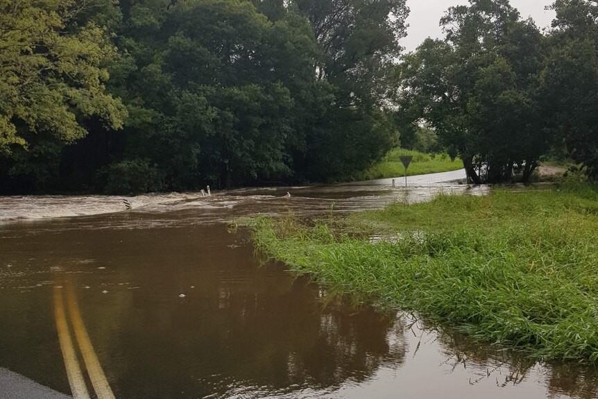 A road cut off by flooding at a creek crossing