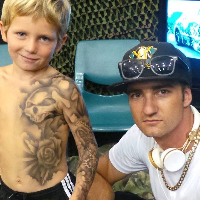 Benjamin Lloyd with a child he has given an airbrushed, temporary tattoo.