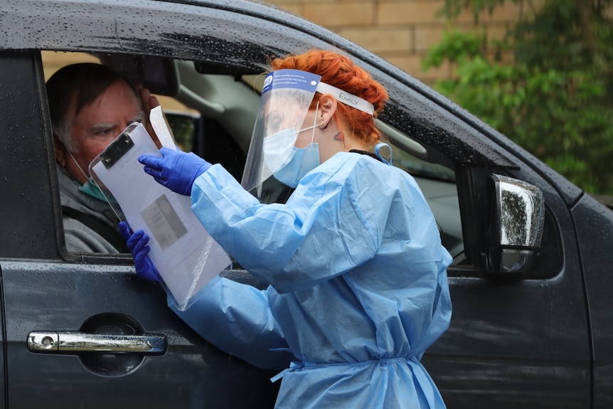 A man in his car getting a COVID-19 test